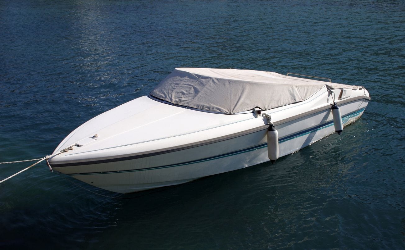 A small boat with a cover on it in the water.