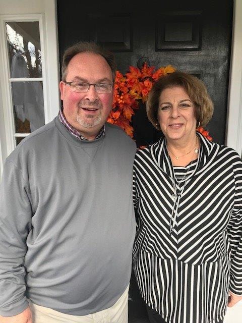 A man and woman standing in front of a door.